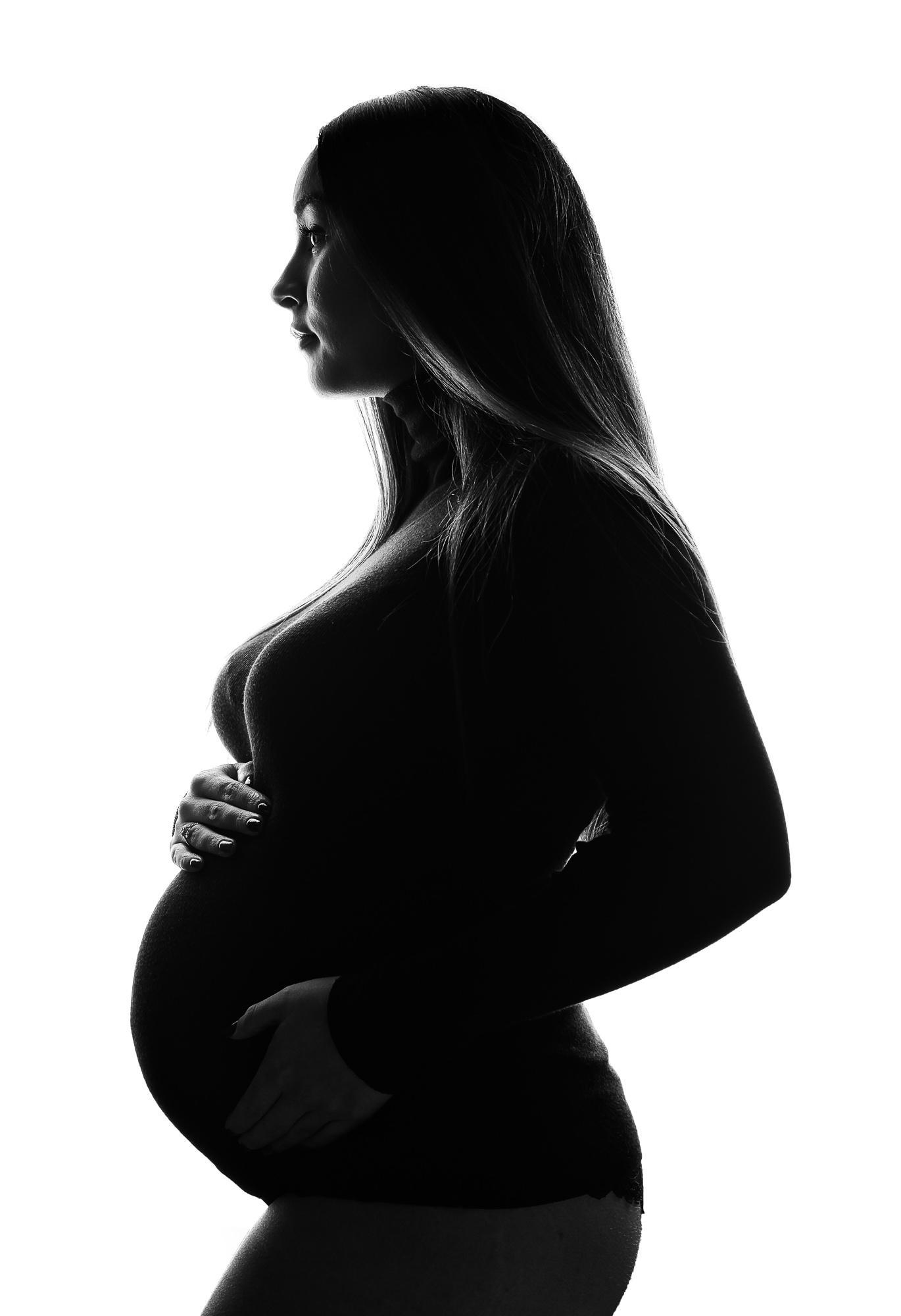 black and white image of mother holding her bump