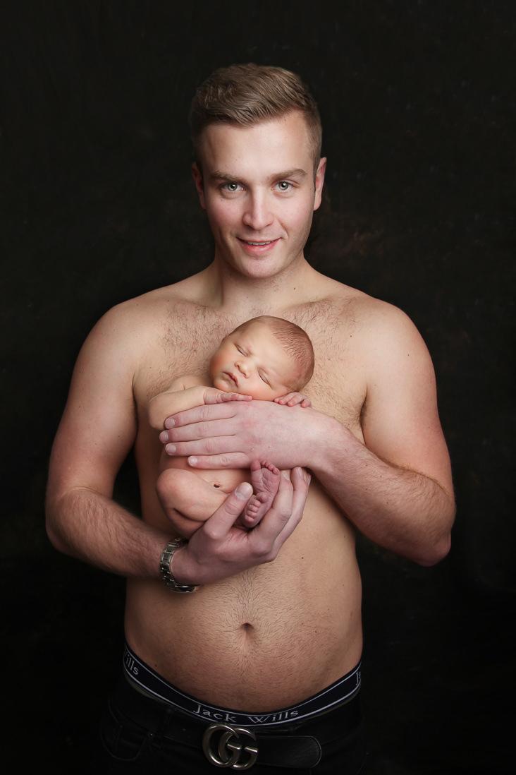 dad holding his newborn baby skin to skin