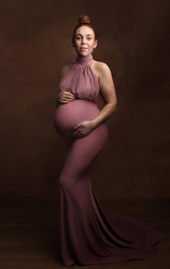 beautiful pregnant lady in a pink dress with red hair, photographed by Newborn Photographer Leeds